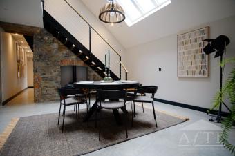 Dining room with limestone wall and period staircase at 59 William Street