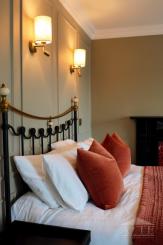 Bedroom detail with period-style bed and warm lighting