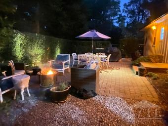 Fenced in backyard with grill and firepit.